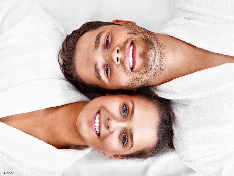 A man and woman together smiling confidently, reinforcing that liposuction is for everyone, regardless of gender